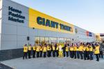 Giant Tiger Camrose, Alta., staff members pose outside in front of the store with their hands in the air. 