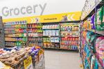 Giant Tiger Camrose, Alta., featuring shelves of pet essential items such as dog and cat food, with bins of dog bones and treats stationed in front. The word “Grocery” is displayed on the wall above the pet essential shelves. 
