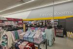 Giant Tiger Saint John, N.B., women’s pajamas section with socks and bras hanging along the back wall beside the fitting rooms and under the words “Fitting Rooms”. 