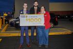 A Giant Tiger Saint John, N.B., employee holding a presentation cheque of $1000 for Read Saint John. 