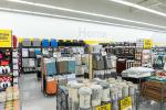 Giant Tiger Vaughan, Ont., home décor section featuring rugs, candles, pillows, and curtains, with the word “Home” displayed on the back wall over the shelves of plastic bins. 