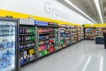 Giant Tiger Vaughan, Ont., grocery aisle featuring shelves containing an assortment of pop, seltzer waters, and chips. The word “Grocery” is displayed on the wall above the shelves of items. 